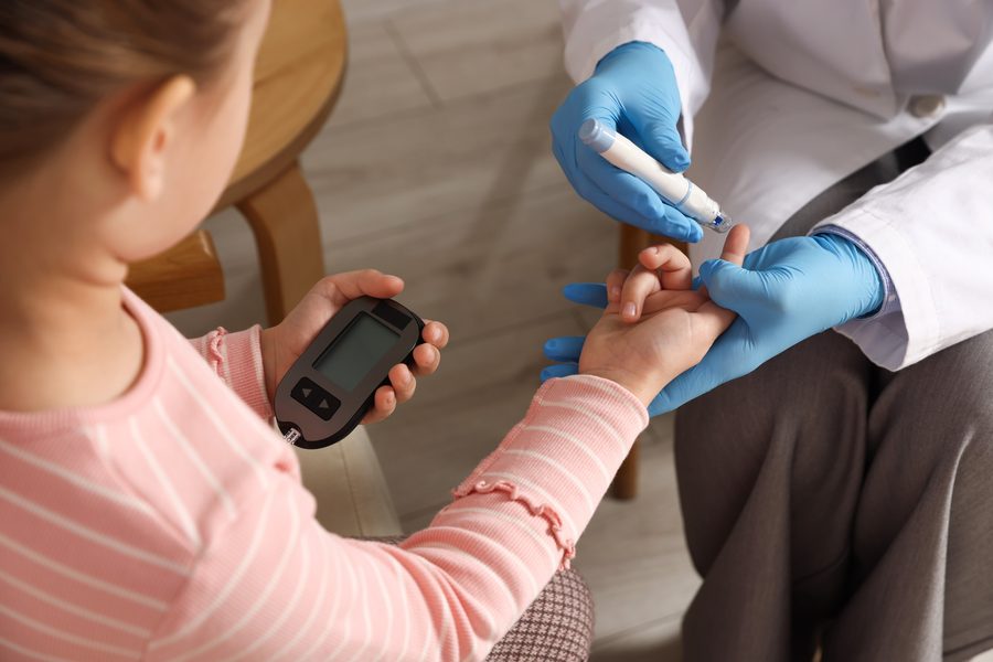 School nurse checking a child's blood glucose level